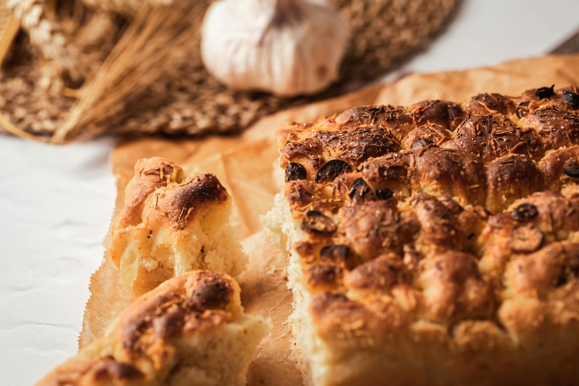 Domowa focaccia z czosnkiem i rozmarynem na papierze do pieczenia