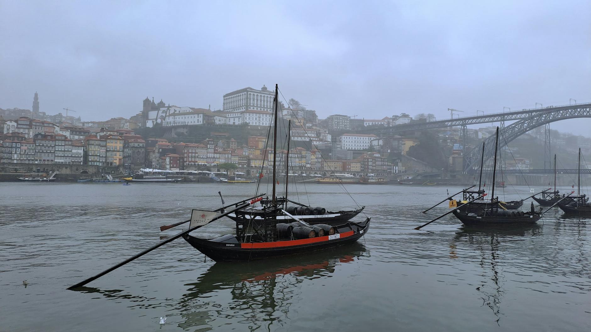 Rabelos na rzece Douro i mglista panorama nabrzeża Porto